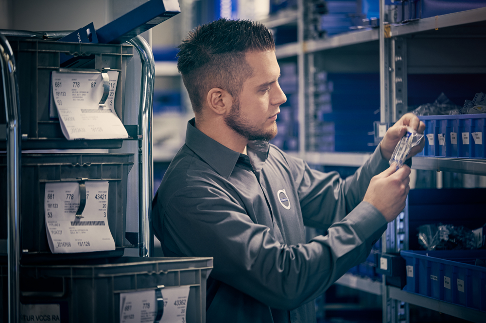 A person is picking parts from a warehouse shelf